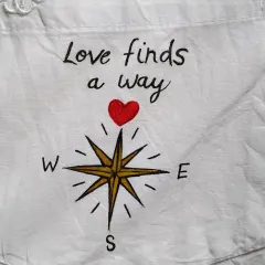 On the pocket of the same anniversary shirt, I painted this "Love finds a way" compass. It's a small detail that adds a lot of meaning to the overall story of the custom apparel.