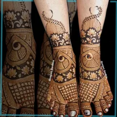 An intricate design for a bride's feet, featuring lotus and peacock motifs. The pattern extends up the ankle in a beautiful vine.