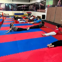 A group of students works on back and shoulder flexibility with a floor exercise. Consistent mobility work is a key part of our program to improve posture and prevent injuries.