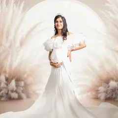 For the mom-to-be who dreams of a fairytale moment. This setup features a regal white gown, a tiara, and a dreamy pampas grass arch, creating an ethereal and angelic portrait. It’s about making you feel like the queen you are during this special time.