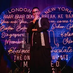 A stylish groom posing in front of a custom neon sign at the sangeet. We capture the cool, personalized details that make your event unique.