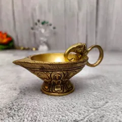 This brass diya features an elephant head on the handle, a symbol of good luck. The antique finish and solid build make it a wonderful lamp for your daily prayers.