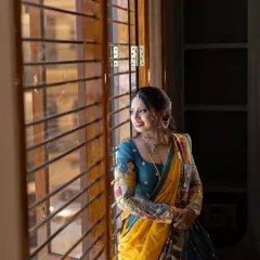 A portrait capturing the feeling of a dream realized. Here, the homeowner looks out from her new home during the Gruha Pravesha, dressed in a stunning traditional outfit.