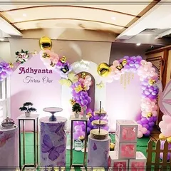 An elegant butterfly garden theme for a first birthday party. This setup uses a soft purple and pink color palette with beautiful balloon arches, large butterfly wing cutouts, and themed pedestals for the cake display.