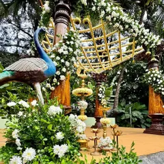 A close-up of our traditional decor, featuring a brass peacock, marigold flowers, and classic South Indian brass lamps (diyas), all coming together to create a divine setting.