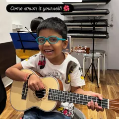 Look at that smile. The ukulele is such a happy instrument, and this is the pure joy I aim for in my classes. This image captures the moment a child connects with music, and the call to action invites other kids to experience it for themselves.