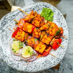 Another look at our delicious paneer tikka, beautifully plated on a stone-textured dish with fresh garnishes.
