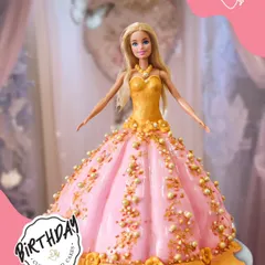 A classic Barbie doll cake, where the doll is dressed in an elegant gown made of pink and gold fondant. This cake is a showstopper, perfect for a glamorous and unforgettable birthday party.