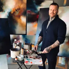 We are proud to collaborate with internationally acclaimed artists like Simon Kenny. This photo captures him in his studio, surrounded by the 'lyrical abstraction' works that have captivated collectors worldwide and which we were honored to showcase in his 'Mystic Mirage' solo show.