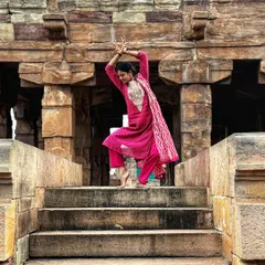 Striking a classical pose on the steps of a temple, connecting with the centuries of art and history carved into the stone.