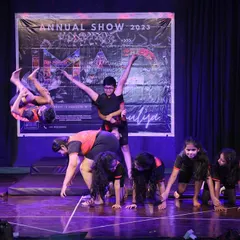 We safely guide our students to master advanced acrobatic skills like this dynamic aerial flip. This moment from our annual showcase captures the power and confidence our young gymnasts develop.