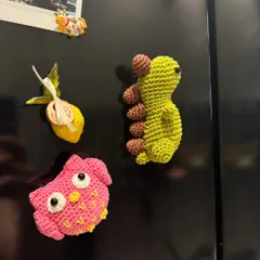 Add a bit of handmade charm to your fridge with our crochet magnets. This photo shows a cute owl and a dinosaur, perfect for holding up notes and photos.