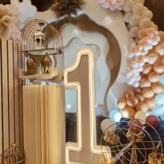 A light-up number '1' is a must-have prop for a first birthday party. This neon-style number adds a modern and stylish touch to the cake table area and is great for photos.