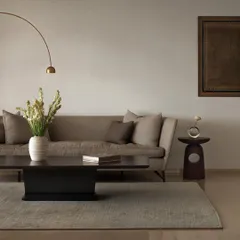 We designed the furniture in this living room to create a soft, elegant, and cohesive space. The low-profile coffee table, sculpted wooden side table, and arched floor lamp work together to establish a calm and inviting atmosphere.