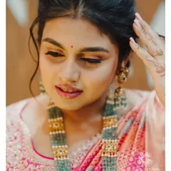 A close-up of the beautiful Varsha. This shot highlights the soft, blended eyeshadow and the messy, romantic updo we created for her, showing the importance of texture in a bridal look.