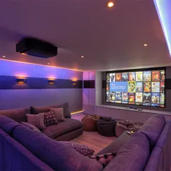 Your home theater should fit your lifestyle. Here, we created a comfortable and casual entertainment space using a large sectional sofa and beanbags, perfect for family movie marathons or gaming sessions with friends.