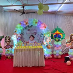 This decoration was for a combined first birthday and naming ceremony with a princess and Radha-Krishna theme. I used a pastel balloon arch, a custom 'Happy Birthday Princess' backdrop, and various character cutouts.
