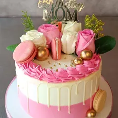 This is the beautiful cake that brought a big smile to a customer's mom. It's a pink and white drip cake decorated with fresh roses and macarons.