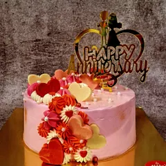 Celebrate your journey together with this beautiful anniversary cake. It's decorated with a cascade of red, pink, and white hearts, a custom 'Happy Anniversary' topper, and delicate pearl details.