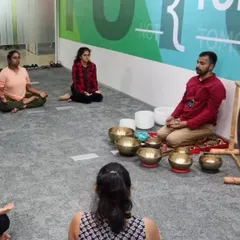 Here you can see a small group of professionals seated in meditation. This phase of the session helps quiet the mind before the deep relaxation of the sound bath, and it can be done right in a company meeting room.