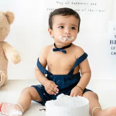Getting messy is the best part! This little boy is enjoying his first taste of birthday cake during his minimalist-themed cake smash session in my Bangalore studio.