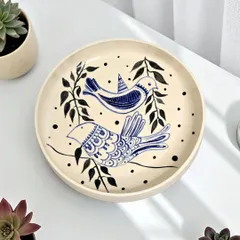 This hand-painted ceramic plate features a delicate bird motif, symbolizing freedom and a connection to nature. Meticulously wheel-thrown, it serves as a gentle reminder to pause and embrace the present moment.