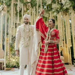 A moment of pure celebration as the couple rejoices after their wedding ceremony. The bride's raised hand and joyful expression say it all.
