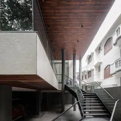 We believe in architecture that makes a statement. Here, a bold cantilevered structure and a sculptural floating staircase create a powerful entry experience. The design emphasizes clean structural forms, using materials like wood, stone, and glass to create a modern home that feels both bold and timeless.
