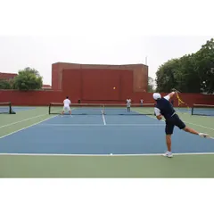 A player executes a powerful forehand during a doubles practice match. Our training incorporates extensive match-play scenarios to build tactical awareness.
