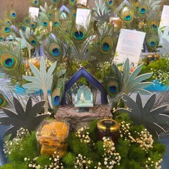 A close-up of one of the "Little Kanha" hampers. You can see the details, including the miniature idol, peacock feathers, custom paper cutouts, and curated goodies like cookies and honey.
