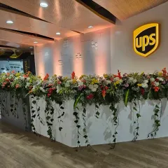 I transform standard office areas into vibrant, welcoming spaces. This lush floral arrangement on the UPS reception desk adds a touch of nature and sophistication for your launch event.
