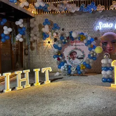 I love hosting first birthday parties. Here’s a complete setup with large light-up letters spelling the birthday boy's name, a custom photo backdrop, and a balloon arch.