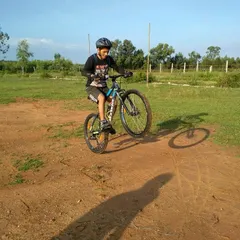 A rider showing off some skills with a wheelie on a dirt track. Our off-road rides are a great place to have fun and test your bike handling.