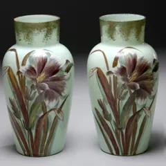 A beautiful pair of hand-painted baluster-shaped vases from the late Victorian period. Made of soft mint green Opaline glass, they feature delicate iris flowers, showcasing the fine craftsmanship of 19th-century European decorative arts. These pieces came to us from the distinguished collection of Meena Appachu.