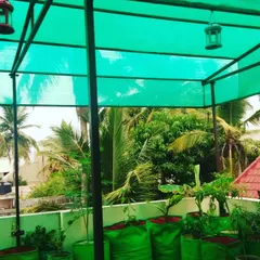 A view of a thriving terrace garden, complete with a shade net structure. Using grow bags allows for a flexible setup, so you can grow a variety of vegetables, herbs, and even small fruit trees.