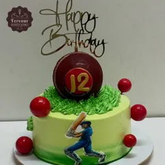 A fun cricket theme cake for a 12th birthday. This design includes a large cricket ball on top, a batsman figure, and a "Happy Birthday" topper, perfect for a young sports enthusiast.