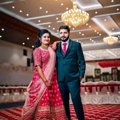 A classic wedding reception look. The couple stands against a beautiful floral wall, ready to greet their guests in a hall that I've decorated to feel grand and welcoming.