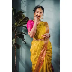 A classic South Indian bridal look. This portrait, shot indoors, uses directional light to highlight the rich texture of the yellow silk saree and the intricate details of the temple jewelry.