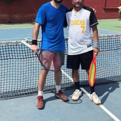 Two players sharing a friendly moment on the hard court after a good match. We encourage sportsmanship and camaraderie among all our members.
