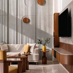 **Amber House, Ahmedabad:** We designed this feature wall with a subtle mural and integrated wooden elements to add texture and character without overwhelming the minimalist aesthetic. Sunlight streams in, highlighting the forms and creating a serene, artful atmosphere in the living area.