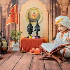 A quiet, studious moment as the baby looks at a holy book. This pose adds a serene and thoughtful dimension to the 'Chota Varkari' themed baby shoot.