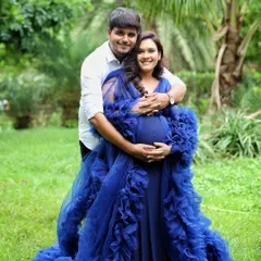An outdoor couple's portrait surrounded by lush greenery. The vibrant blue of her gown stands out beautifully against the natural backdrop, creating a striking and romantic image.