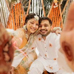 A fun, interactive selfie-style shot from the Haldi ceremony. This unique perspective brings you right into the moment, capturing the couple's joyful, turmeric-covered faces and their henna-adorned hands.
