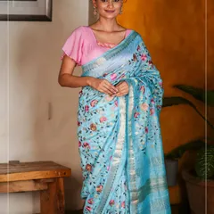 A beautiful sky-blue linen saree with delicate floral embroidery. This piece is light, airy, and perfect for a summer brunch or a day event.