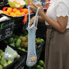 Here’s the crochet market bag in use. It stretches to fit your items and is easy to carry over your shoulder, making it a practical and eco-friendly choice.