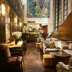 The lounge area at Indian Accent, with its high ceilings, warm wood paneling, and vibrant artwork. It’s more than a backdrop; it’s part of the experience.