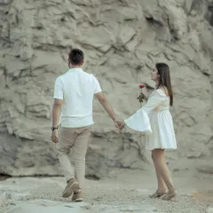 A slight variation of the previous shot, capturing the moment the bride, holding a single red rose, is led by the groom. It’s a simple, powerful storytelling image.