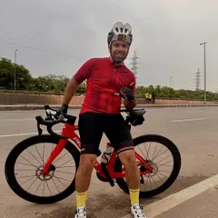 A rider taking a break on the highway with his Pinarello, giving a thumbs-up to the camera.
