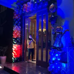I can decorate the entire venue for your themed party. This Halloween entrance features a balloon column in spooky colors, a lighted pumpkin scarecrow figure, and dramatic blue lighting to set a fun and eerie mood right from the door.