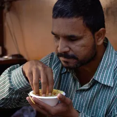 A man eats his meal with focus and gratitude. Our Sattvic meals are designed to nurture not just the body, but also the mind and spirit.